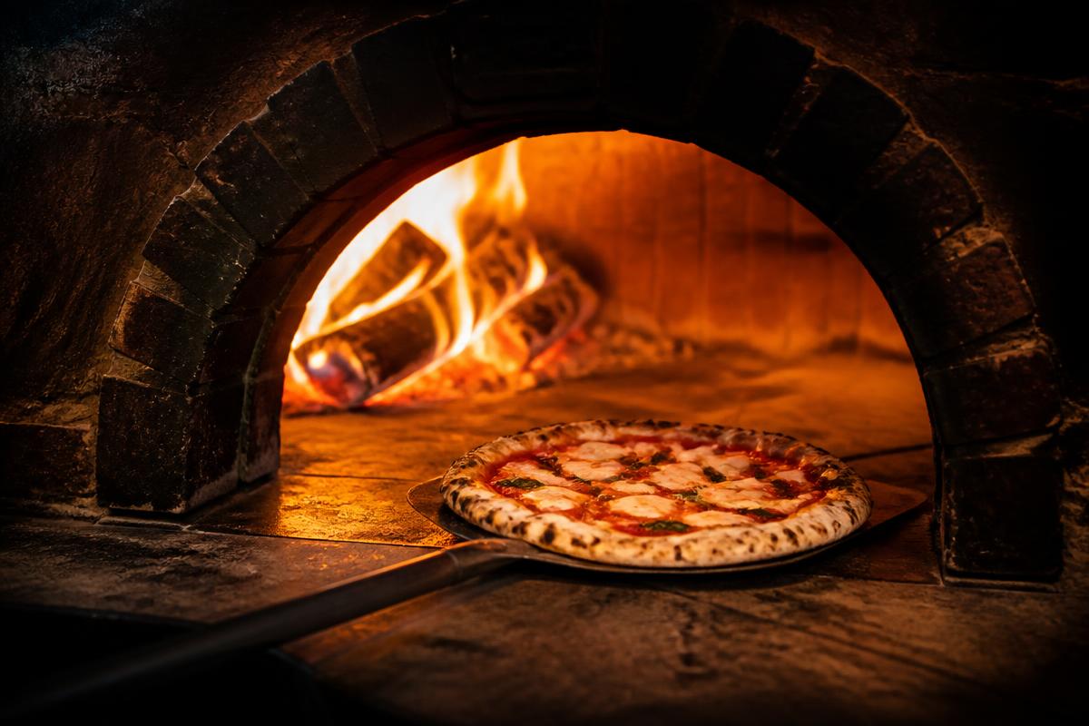 Pizza se peče u krušnoj peći sa otvorenim plamenom